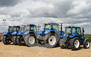 A group of blue tractors parked up