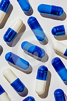 A group of blue and white pills on a white surface