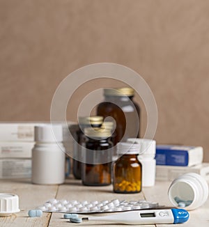 A group of boxes of medicines, pill bottles, thermometer and blisters of pills
