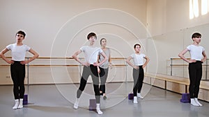 Group of boys on ballet gymnastics class with their teacher performing exercise