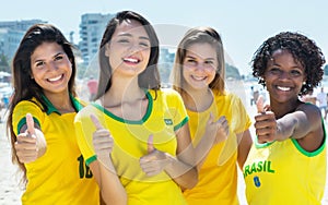 Group of brazilian soccer fans showing thumbs outdoor in the city photo