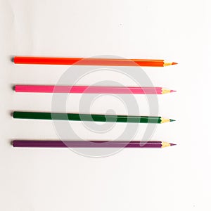 A group of brightly colored pencils placed creatively on a white background.