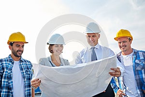 Group of builders and architects with blueprint