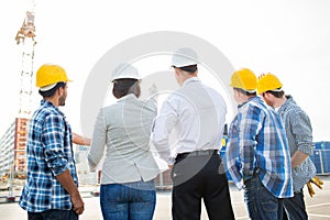 Group of builders and architects at building site