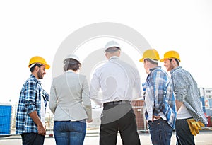 Group of builders and architects at building site