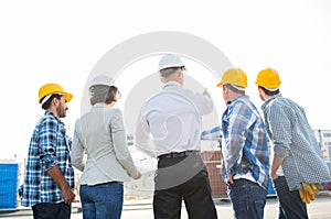 Group of builders and architects at building site