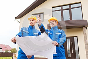 Group of builders with blueprint pointing finger