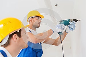 Group of builders with drill indoors