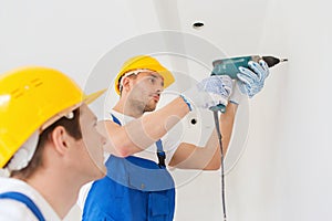 Group of builders with drill indoors