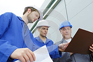 Group builders in hardhats with clipboard