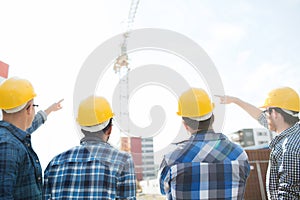 Group of builders in hardhats at construction site