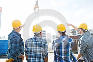 Group of builders in hardhats at construction site