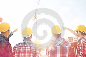 Group of builders in hardhats at construction site