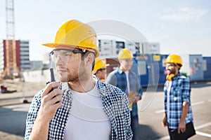 Group of builders in hardhats with radio