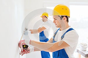 Group of builders with measuring tape indoors
