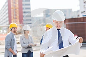 Group of builders with tablet pc and blueprint