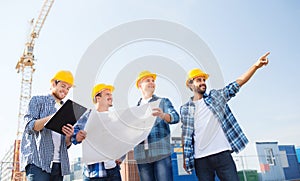 Group of builders with tablet pc and blueprint