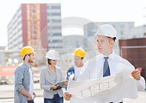 Group of builders with tablet pc and blueprint