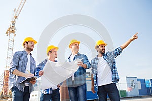 Group of builders with tablet pc and blueprint