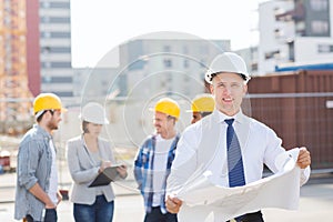 Group of builders with tablet pc and blueprint