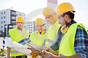 Group of builders with tablet pc and blueprint