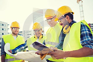 Group of builders with tablet pc and blueprint