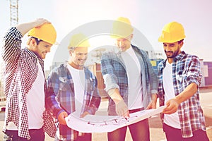 Group of builders with tablet pc and blueprint