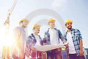 Group of builders with tablet pc and blueprint