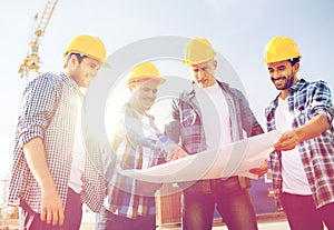 Group of builders with tablet pc and blueprint