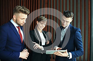 Group of buisness people working on tablet.