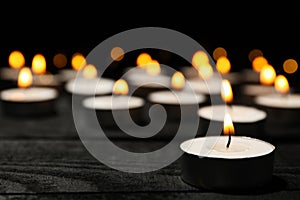 Group of burning candles on black background