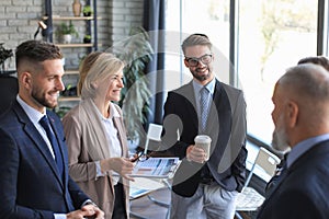 Group of business collegues discussing ideas and planning work during coffee break in office photo