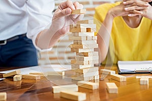 Group of business creative people building tower by wooden block