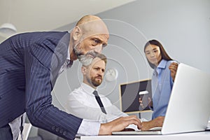 Group of business partners looking at laptop screen for presentation of new project