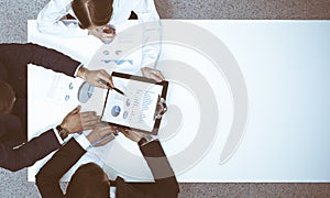 Group of business people analyzing financial documents, view from above. Business team at meeting