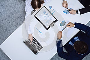 Group of business people analyzing financial documents, view from above. Business team at meeting