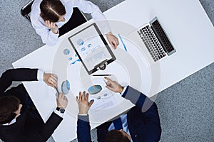 Group of business people analyzing financial documents, view from above. Business team at meeting