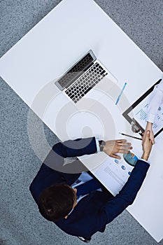 Group of business people analyzing financial documents, view from above. Business team at meeting