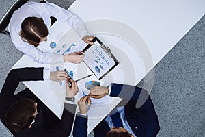 Group of business people analyzing financial documents, view from above. Business team at meeting