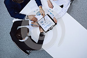 Group of business people analyzing financial documents, view from above. Business team at meeting