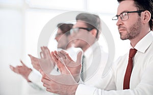 Group of business people applauding sitting at the office table.