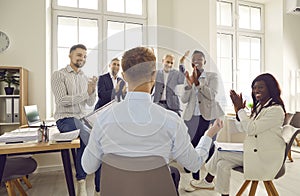 Group of business people applauding their colleague after presentation