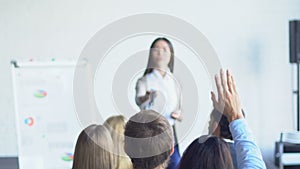 Group Of Business People Asking Question To Businesswoman Leading Presentation Discussing Financial Report