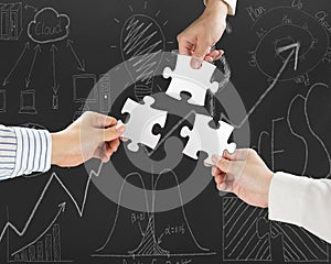 Group of business people assembling blank white jigsaw puzzles