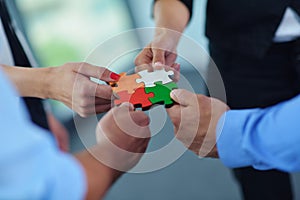 Group of business people assembling jigsaw puzzle