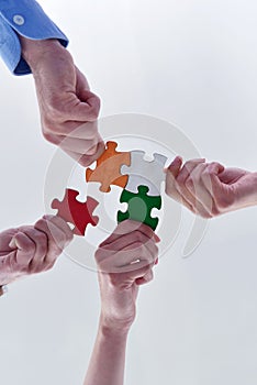 Group of business people assembling jigsaw puzzle