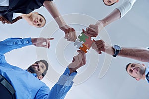 Group of business people assembling jigsaw puzzle