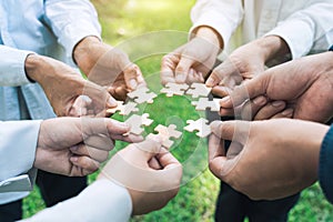 group of business people assembling jigsaw puzzle. The concept of cooperation, teamwork, help and support in business