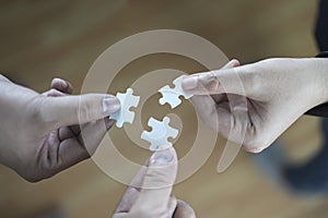 Group of business people assembling jigsaw puzzle and represent team support