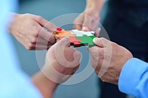 Group of business people assembling jigsaw puzzle